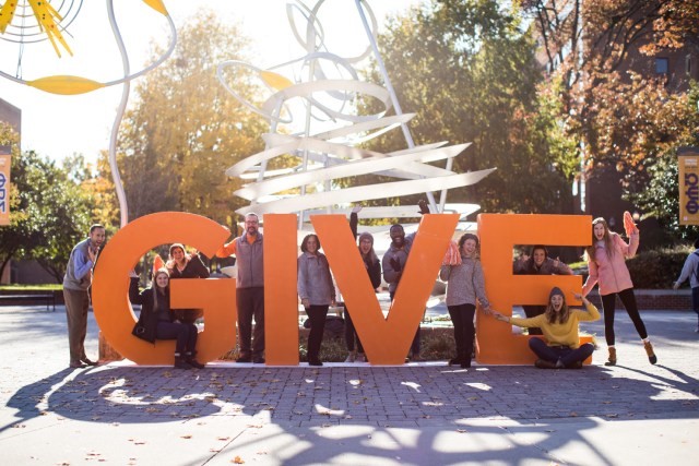 6-foot-high sculpted orange letters read "GIVE"