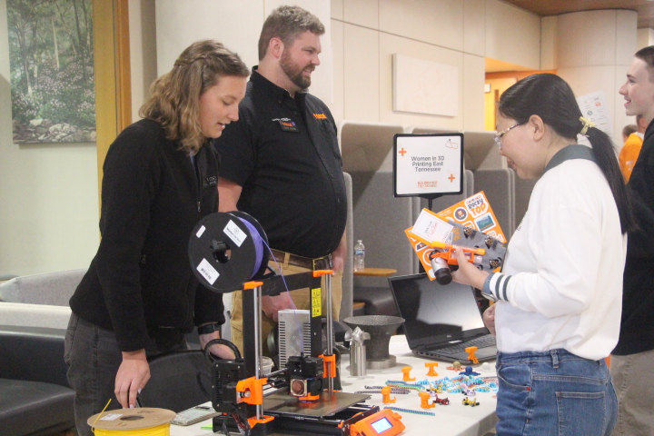 Students view a 3D printer during tabling event